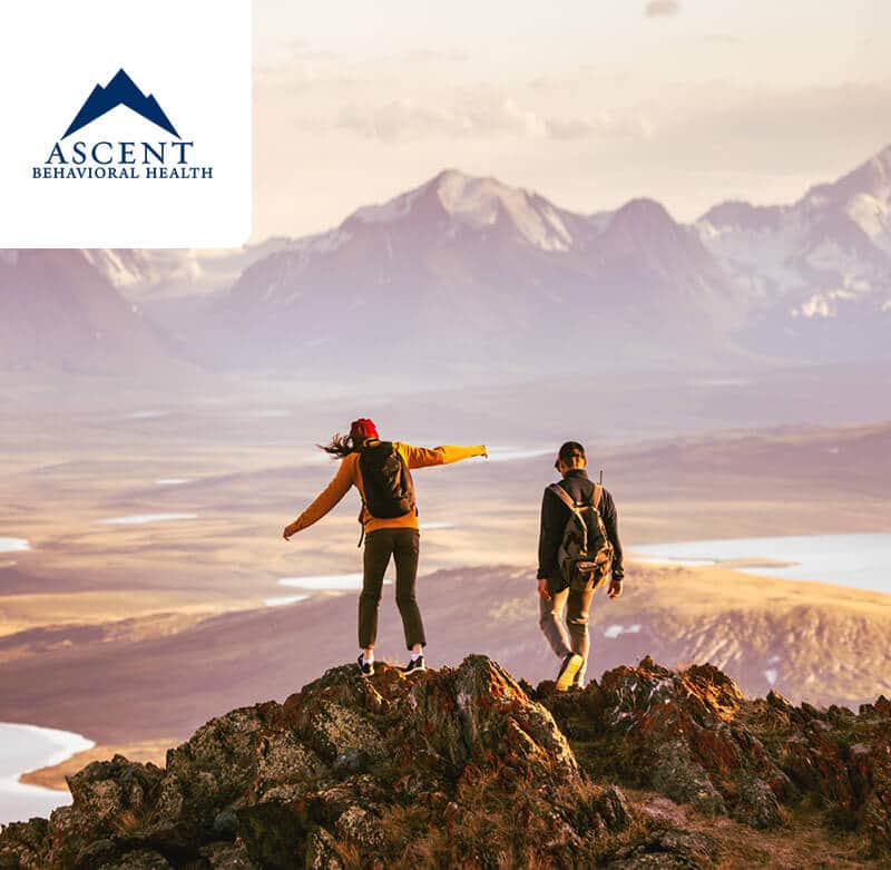 Two adults at the top of a mountain